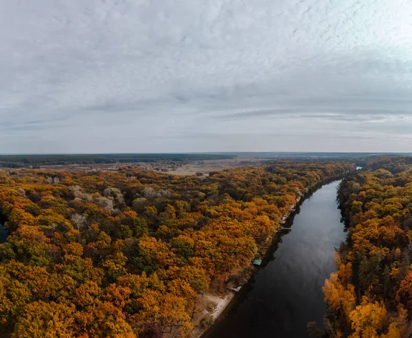 Autumn aerial river valley and colorful golden forest. Flying above autumnal trees in rural riverside in Ukraine