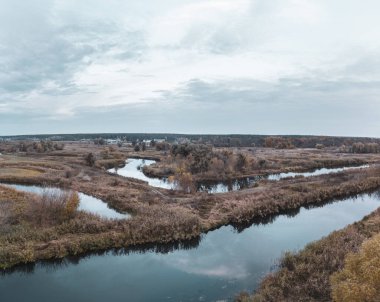 Akşamları Ukrayna 'da çıplak ağaçlar ve bulutlu gökyüzü ile sonbahar nehri vadisi