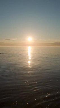 Sakin denizde nefes kesen gün doğumu bulutlu gökyüzü, dikey doğal güzellik