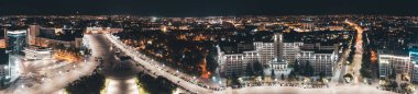 Aerial night Freedom Square panorama with illuminated University and hotel buildings in Kharkiv city center, Ukraine clipart