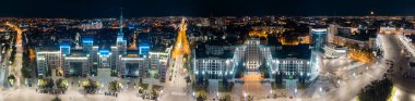 Aerial panorama city downtown with Derzhprom and Karazin National University buildings on Freedom Square in night illuminated Kharkiv city, Ukraine clipart