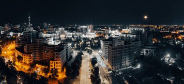 Kharkiv 'deki Klochkivskyj Descent kentinden Derzhprom ve Karazin Üniversitesi binalarıyla hava geceleri Özgürlük Meydanı manzarası aydınlandı