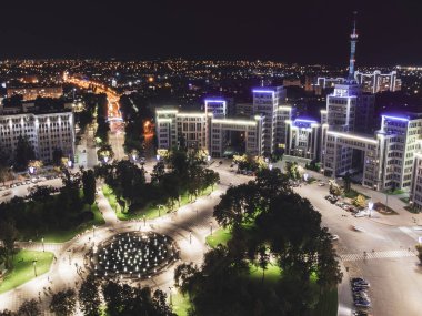 Ukrayna 'nın başkenti Kharkiv' de bulunan Özgürlük Meydanı 'ndaki havacılık gecesi Derzhprom binasında mavi ışık ve çember şeklinde modern çeşme.