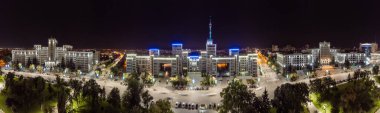 Aerial city panorama of Derzhprom and Karazin University buildings on Freedom Square in night illuminated Kharkiv, Ukraine clipart