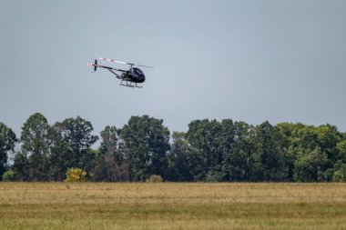 Ukrayna helikopteri Aerokopter AK1-3 Sanka mavi gökyüzünde hava gösterisi alanının üzerinde uçuyor