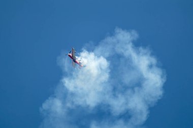 Efsanevi kırmızı Su-31 uçak gösterisi, hava gösterisinde mavi gökyüzünde zıtlıklar sergiliyor.
