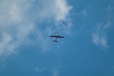 Yakovlev Yak-52 uçak hava gösterisinde bulutlu gökyüzünde akrobatik hareketler yapıyor.