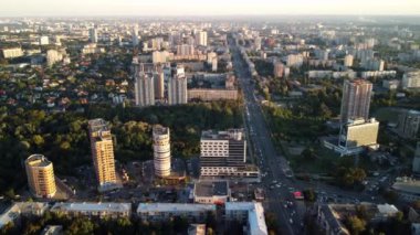 Günbatımı Kharkiv şehrinin yeşil parkı olan yerleşim bölgesindeki yoğun caddelerini gösteren hava hızıyla ilerleyin.