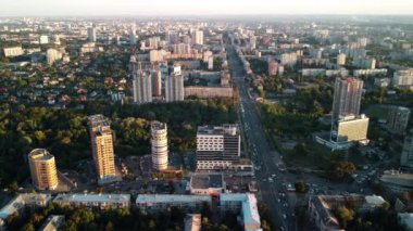 Kharkiv şehrinde günbatımında hava önü görüntüsü yeşil parklı modern evlerde yoğun caddeler.
