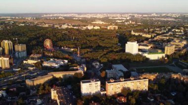 Kharkiv şehir merkezindeki yeşil Central Park yakınlarındaki caddelerde gün batımında dönme dolaba bakan hava manzarası
