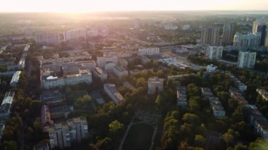 Güneşli günbatımında geriye doğru uçan hava manzaralı Kharkiv şehri yeşil yerleşim bölgesi