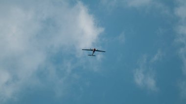 Yakovlev Yak-52 uçak hava gösterisinde bulutlu gökyüzünde akrobasi yapıyor.