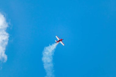 Açık kırmızı uçak Sukhoi Su-31 bir hava gösterisi sırasında mavi gökyüzünde gösteri yapıyor.