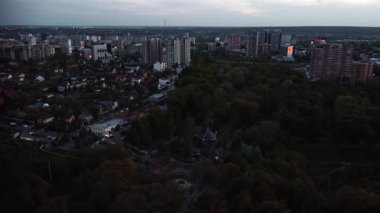 Harkiv üzerinde uçan, modern şehir sokaklarının havası, huzurlu yerleşim alanları ve alacakaranlıktaki yeşil park
