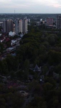 Harkiv üzerinde uçan modern şehir sokakları, huzurlu yerleşim alanları ve alacakaranlıktaki yeşil park