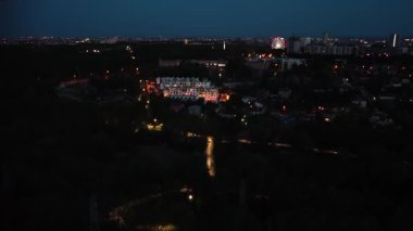 Şehir merkezinin yerleşim bölgesi ve şehir ışıklarıyla dolu eğlence parkı.