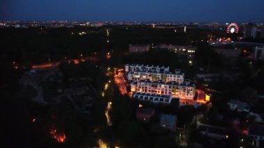 Şehir ışıklarıyla eğlence parkının üzerinde uçan hava gece zaman ayarları