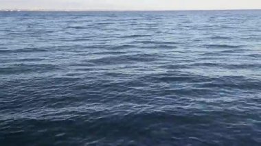 Derin mavi deniz, hareket eden dalgalar aşağı eğik, temiz su yüzeyinin yakın görüntüsü.
