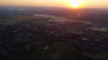 Kırsal arazinin hava panoramik görüntüsü. Gün doğumunda tarım arazisi ve evler.