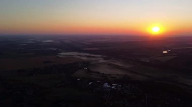 Kırsal kesimde güneş doğumu manzarası yaz tarlaları, sabah sisli küçük köyler.