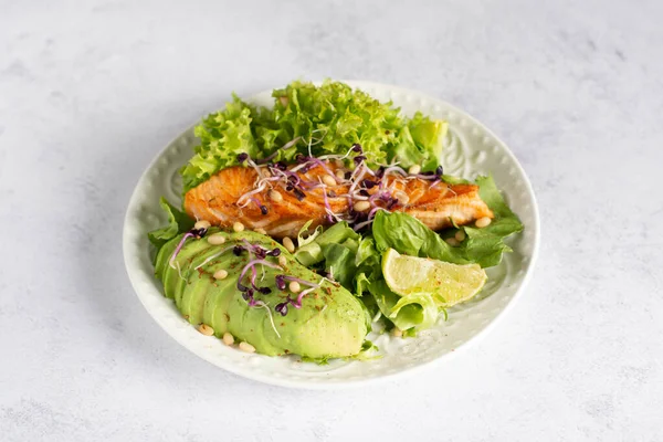 stock image Healthy food baked salmon with lettuce, avocado and microgreens