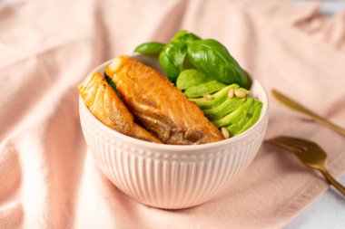 Susamlı somon kasesi, avokado malzemeleri, beyaz arka planda ünlü popüler yemek.