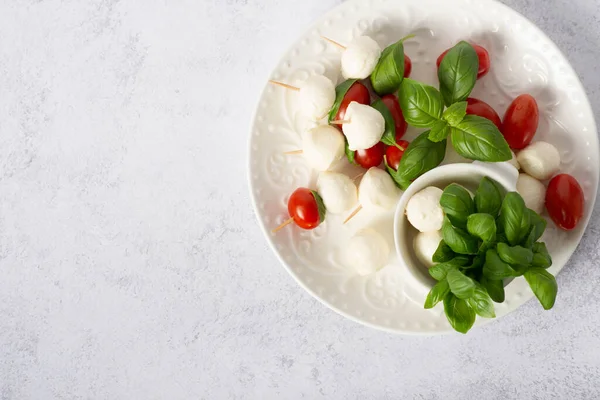 カプレーゼサラダ モッツァレラバジルとトマト串 イタリア料理と健康的な菜食主義者の食事のコンセプト 前菜串モッツァレラとチェリートマト — ストック写真