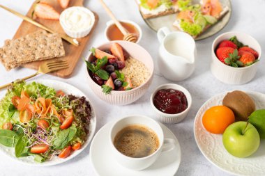 Gri arka planda sağlıklı kahvaltı. Lezzetli ve sağlıklı yemek kavramı. Üst görünüm, boşluğu kopyala. Sağlıklı kahvaltı. Meyve, salata, çilekli yulaf ezmesi. diyet