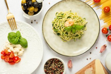 İnce hamurlu pizzalar, karnabahar ısırıkları ve salatalarla dolu bir masa.