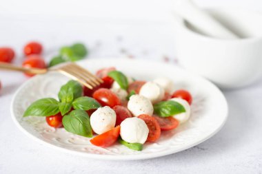 Dilimlenmiş domatesli İtalyan caprese salatası, mozzarella, fesleğen, hafif arka planda zeytinyağı. Caprese salatası
