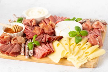 Lezzetli ahşap tabak. Brie peyniri, mavi peynir, salam, tahta üzerinde jambon..