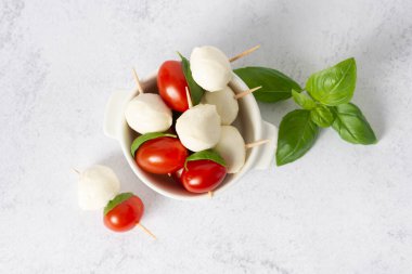 mozzarella, kiraz domatesleri ve taze fesleğen. Caprese salatası için malzemeler. Domates ve fesleğenli mozzarella.