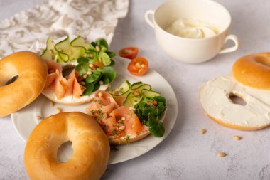 Yemek, öğle yemeği, brunch, tabakta yemek, kaplama konsepti. Somon füme simit, krem peynir ve kapari. Düz konum, üst görünüm arkaplan.