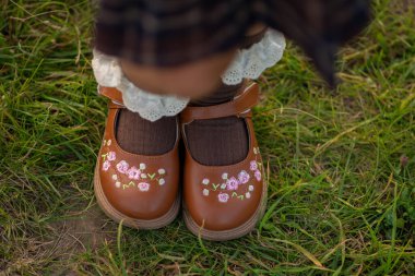 first grader shoes for school. legs of schoolgirls who came to school in the first grade. Nice black elegant shoes clipart