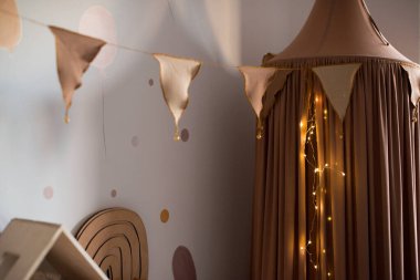 İskandinav tarzı çocuk odası. İçerideki gölgelik, oyuncakların depolanması, küçük bir kızın güzel bir çocuk odasında oynaması.