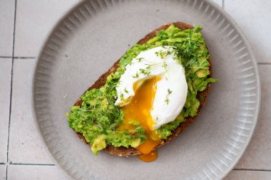 Avokado tostu, tabakta yumurta, açık fayans masası, üst manzara..