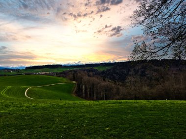 Bereketli bir İsviçre manzarası üzerinde büyüleyici bir gün batımı.