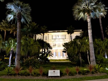 Nice Cte dAzur ve Centre Ville 'i gösteren sokak işaretli aydınlık tarihi bir binanın gece manzarası.