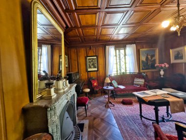 Geleneksel oturma odası ahşap panelli, antika mobilyalı ve klasik dekorlu.