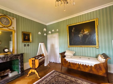 Yüksek tavanlı görkemli bir yemek odası, uzun ve zarif bir masa. Duvarlar portre ve geyik boynuzlarıyla süslenip sofistike ve görkemli bir atmosfer yaratıyor.