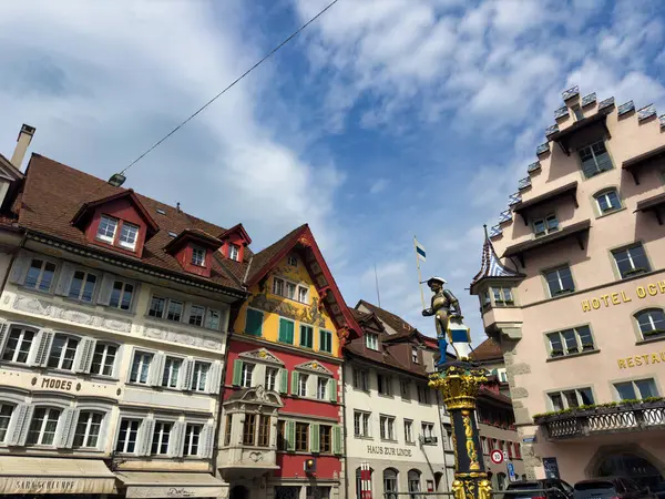 stock image Cozy street in a European town with historic buildings and colorful architecture. The scene features a decorative fountain in the foreground and charming facades of old houses.