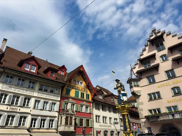 stock image Cozy street in a European town with historic buildings and colorful architecture. The scene features a decorative fountain in the foreground and charming facades of old houses.