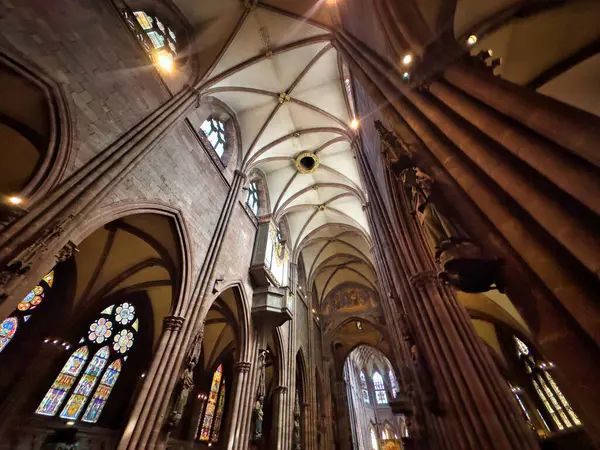 stock image 13.07.24.Germany. Interior of a grand Gothic-style cathedral with high arches, stained glass windows, and an ornate organ. The light streaming through the windows creates a serene and spiritual atmosphere