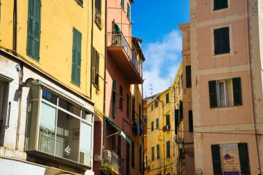 Canlı cepheli renkli binalar, dramatik bir gökyüzü altında manzaralı bir manzara yaratan bir yamaç çiziyor.