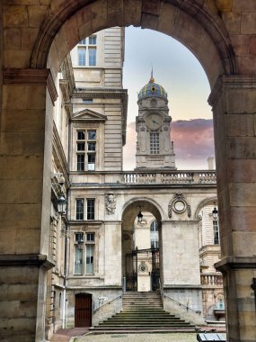 Günbatımı gökyüzü tarafından çerçevelenmiş karmaşık mimarisi olan tarihi bir bina.