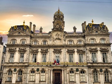 Günbatımı gökyüzü tarafından çerçevelenmiş karmaşık mimarisi olan tarihi bir bina.