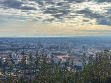 Panoramic city view with vibrant skyline under dramatic cloudy sky clipart