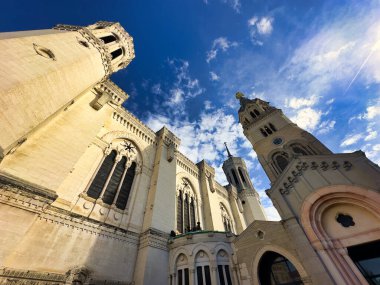 Canlı mavi gökyüzünün altında yüksek kuleleri olan tarihi kilise cephesi