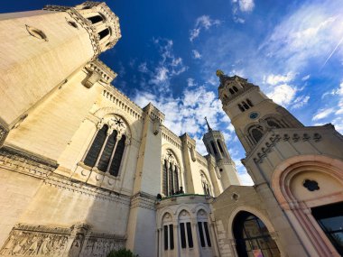 Canlı mavi gökyüzünün altında yüksek kuleleri olan tarihi kilise cephesi