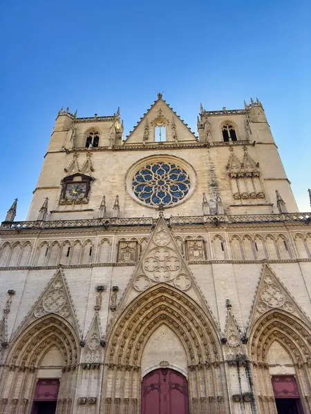 Açık mavi gökyüzüne karşı karmaşık detaylarla dolu Gotik katedral cephesi